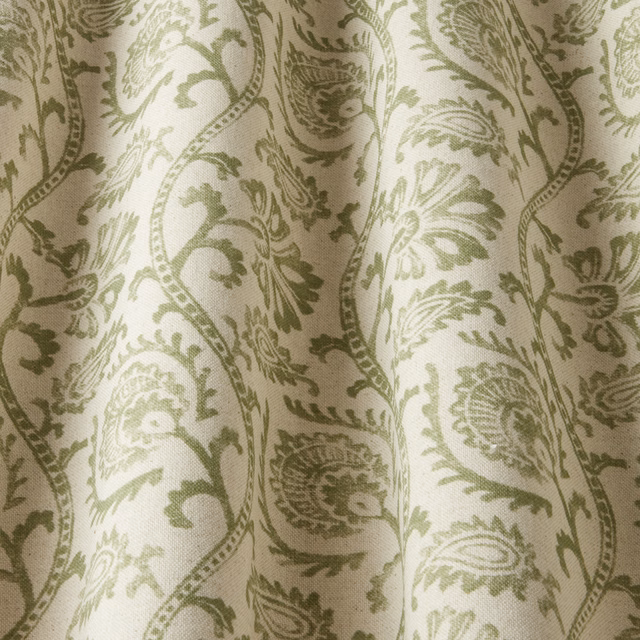 Sage green scrolling floral fabric on an ivory ground with a woven texture