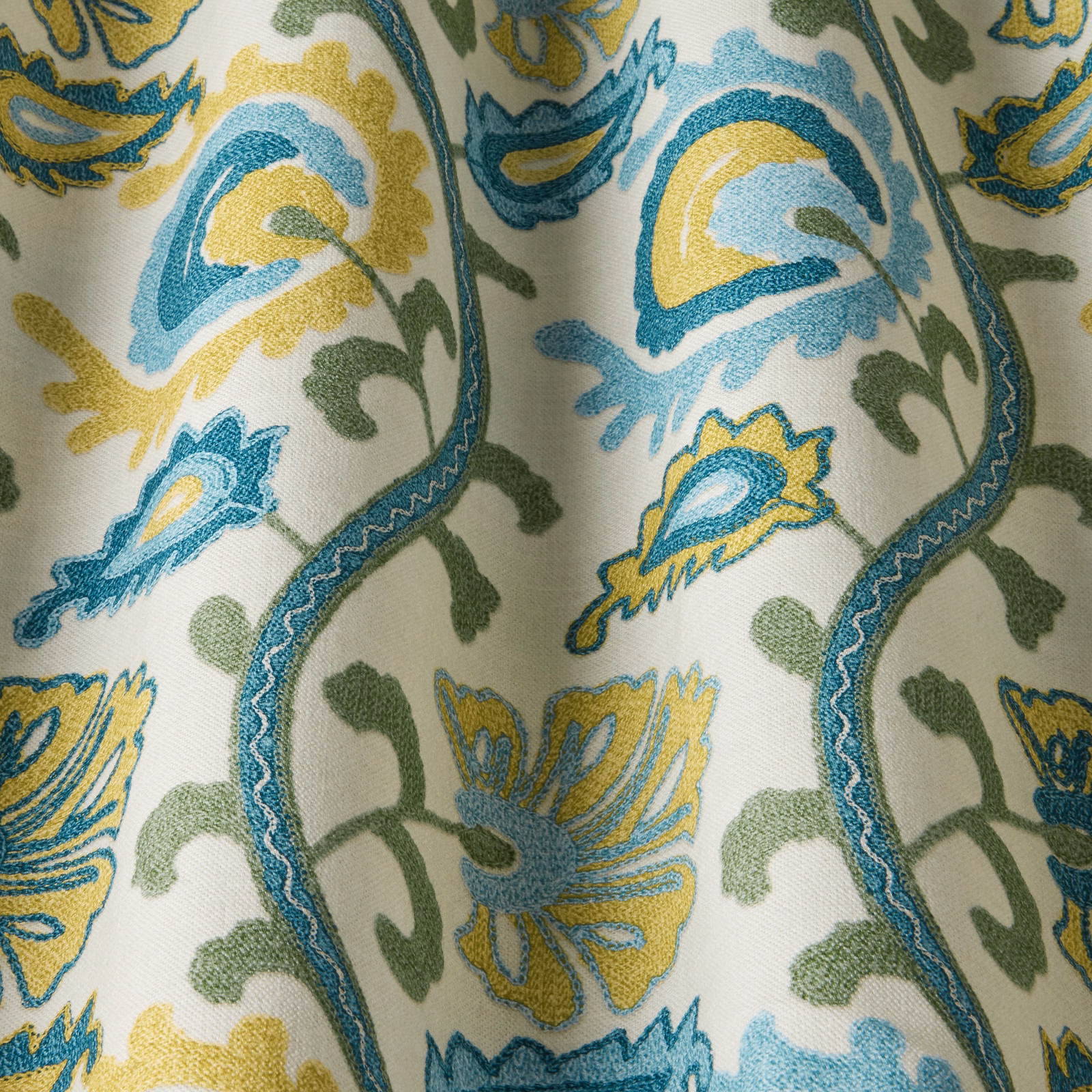 Teal, yellow and green floral fabric swatch on a pale ground with wavy stems