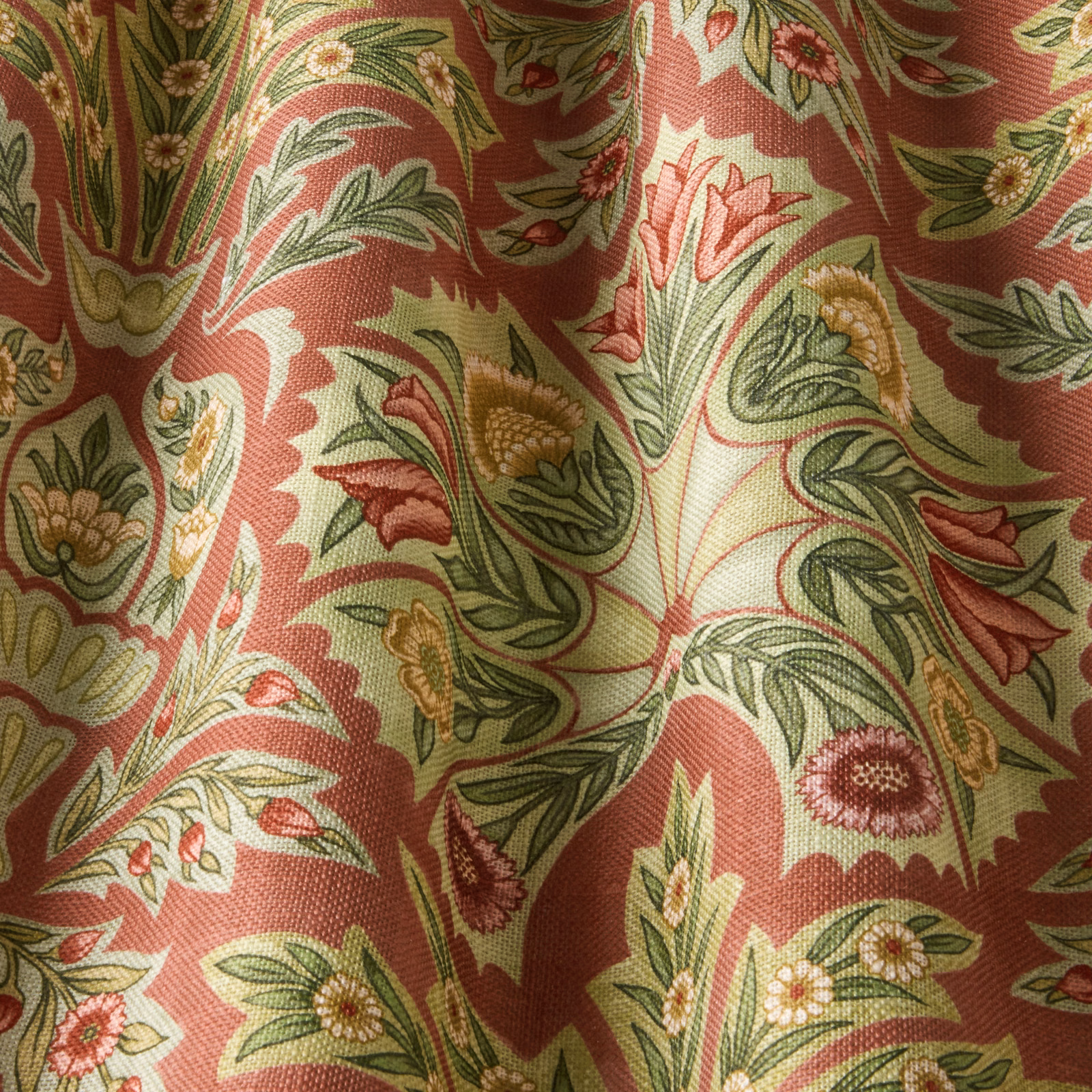 Coral floral damask fabric with green leaves and cream scrolls, draped in folds