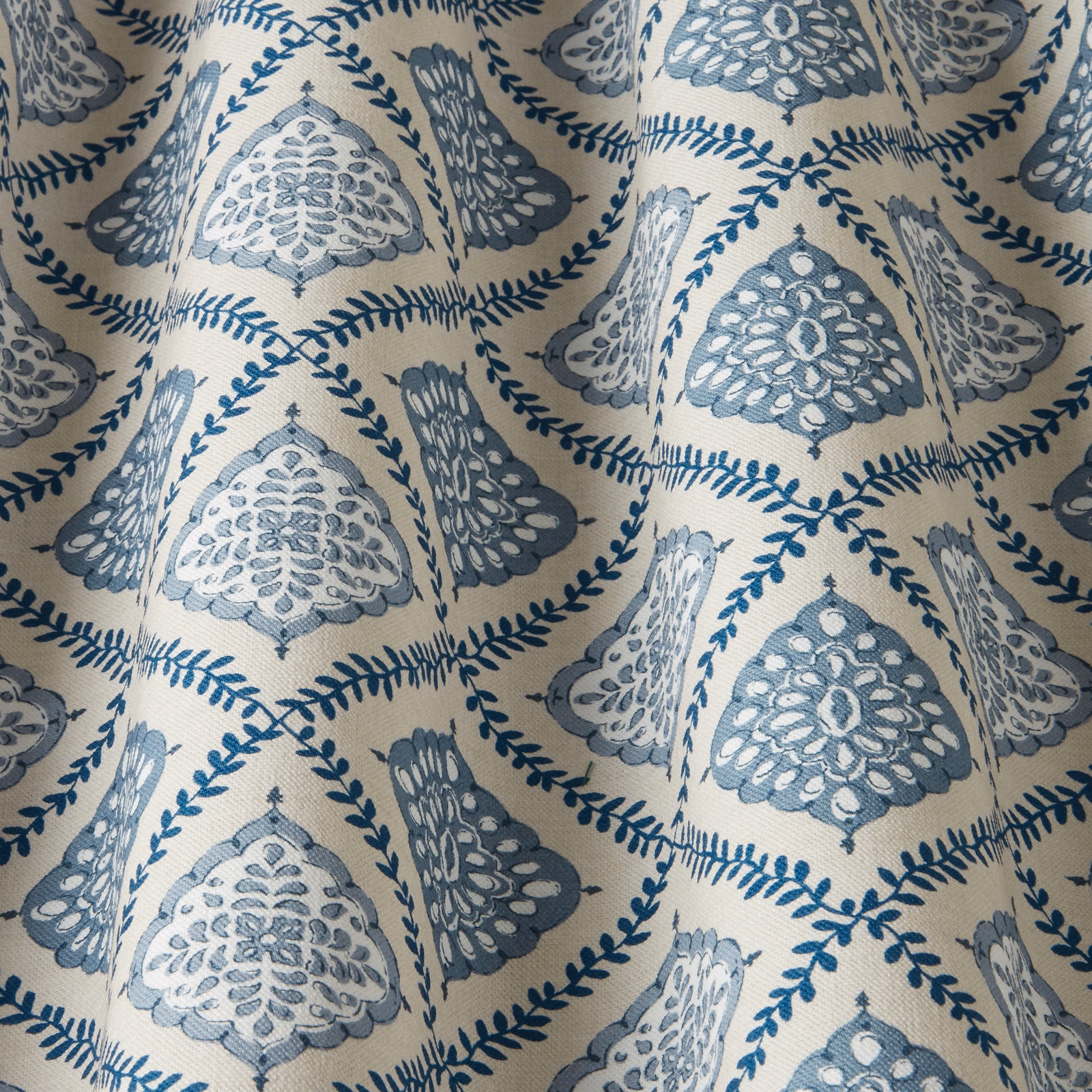 Blue and ivory patterned fabric with arched medallions and leaf trails