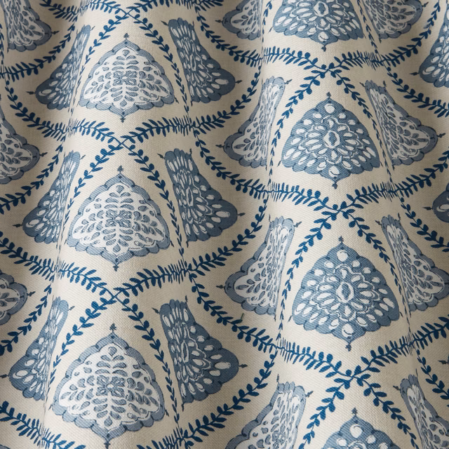 Blue and ivory patterned fabric with arched medallions and leaf trails