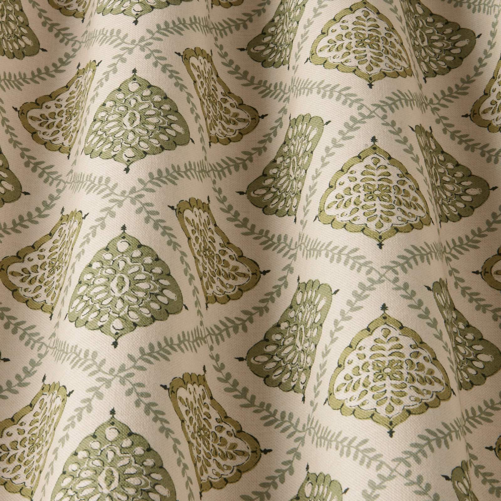 Cream fabric swatch with soft sage green tree motifs and trailing vine pattern