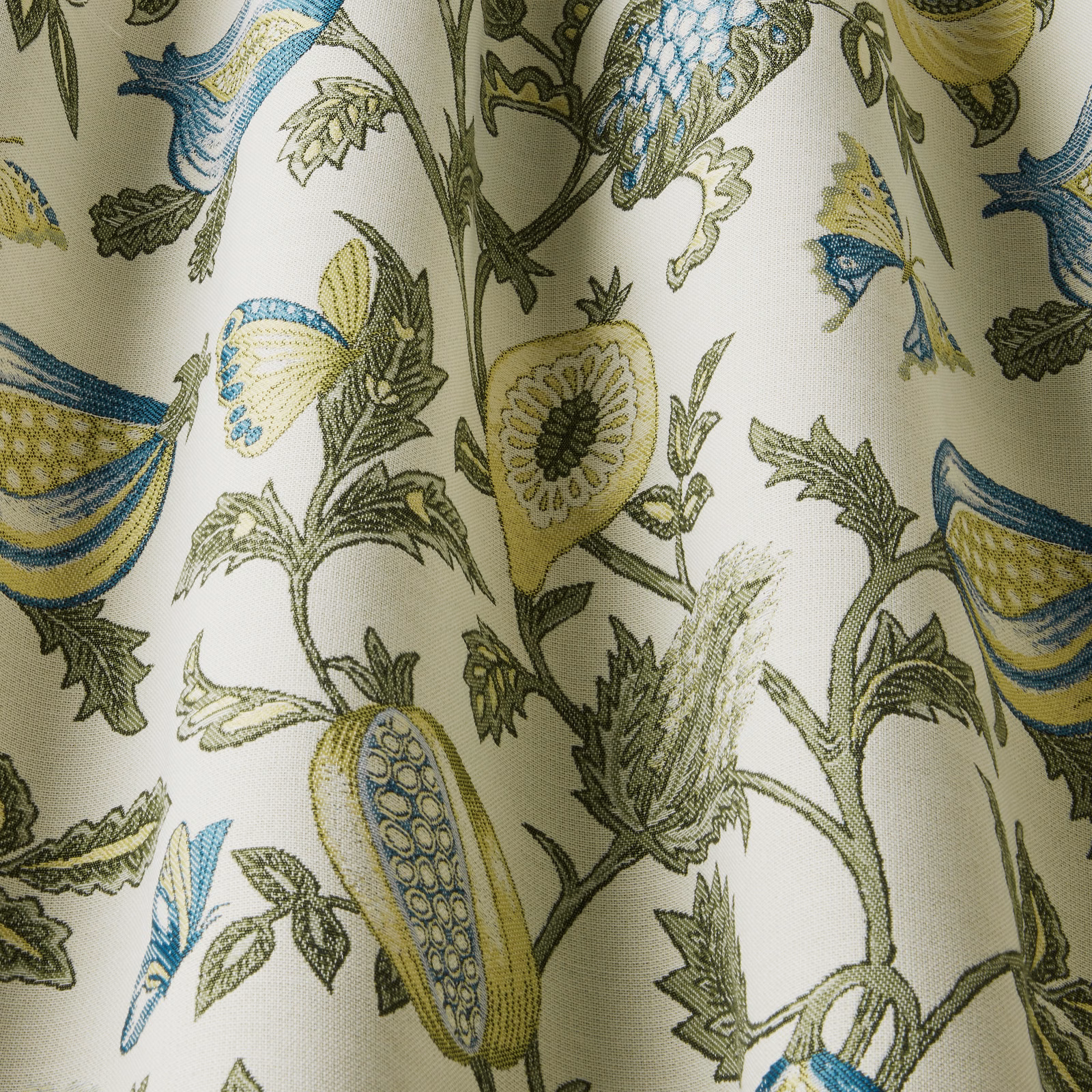 Botanical fabric with teal, lime and olive leaf motifs on a pale cream ground