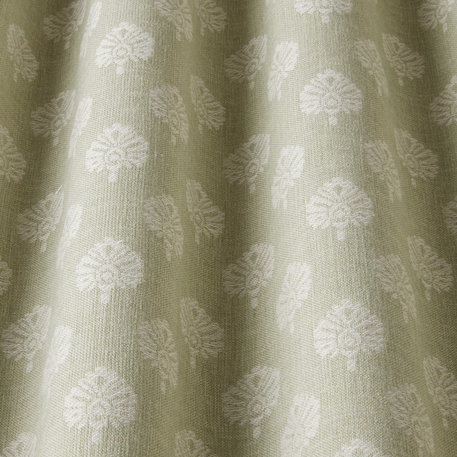 Sage green woven fabric with pale botanical motif and soft vertical folds