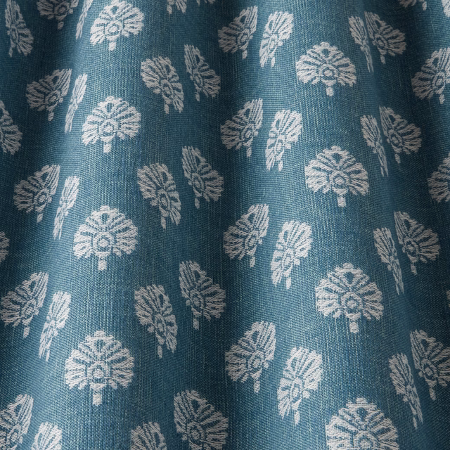 Teal woven fabric with small ivory botanical motifs and visible textured weave