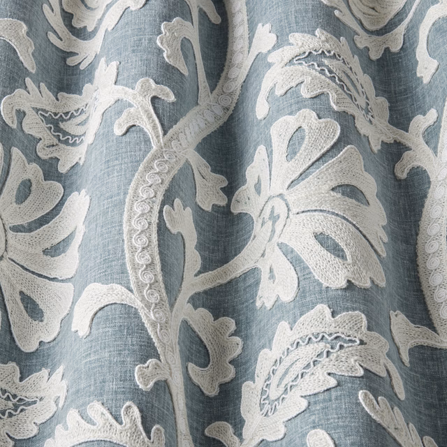 Glacier blue embroidered fabric with raised ivory botanical leaves