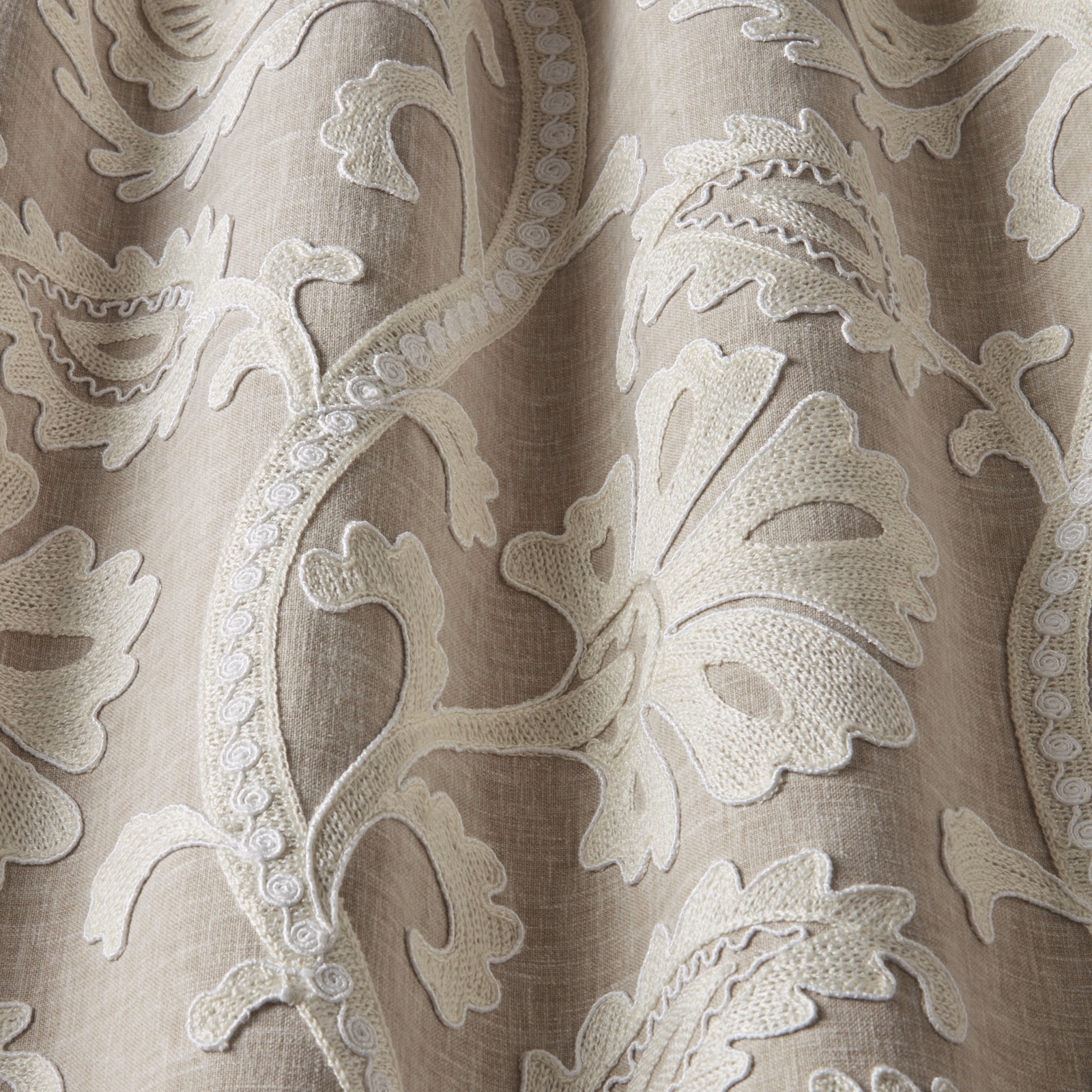 Pale beige embroidered leaf fabric with raised cream scrolls and linen-look texture