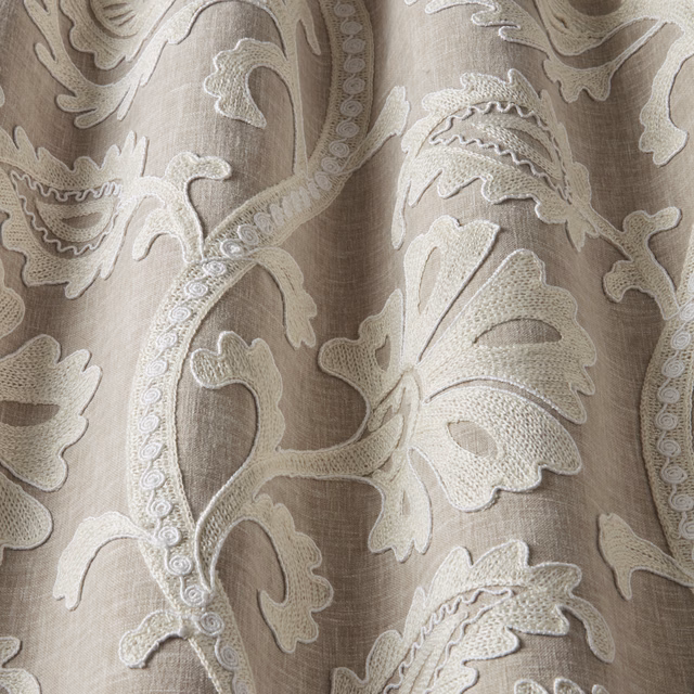 Pale beige embroidered leaf fabric with raised cream scrolls and linen-look texture