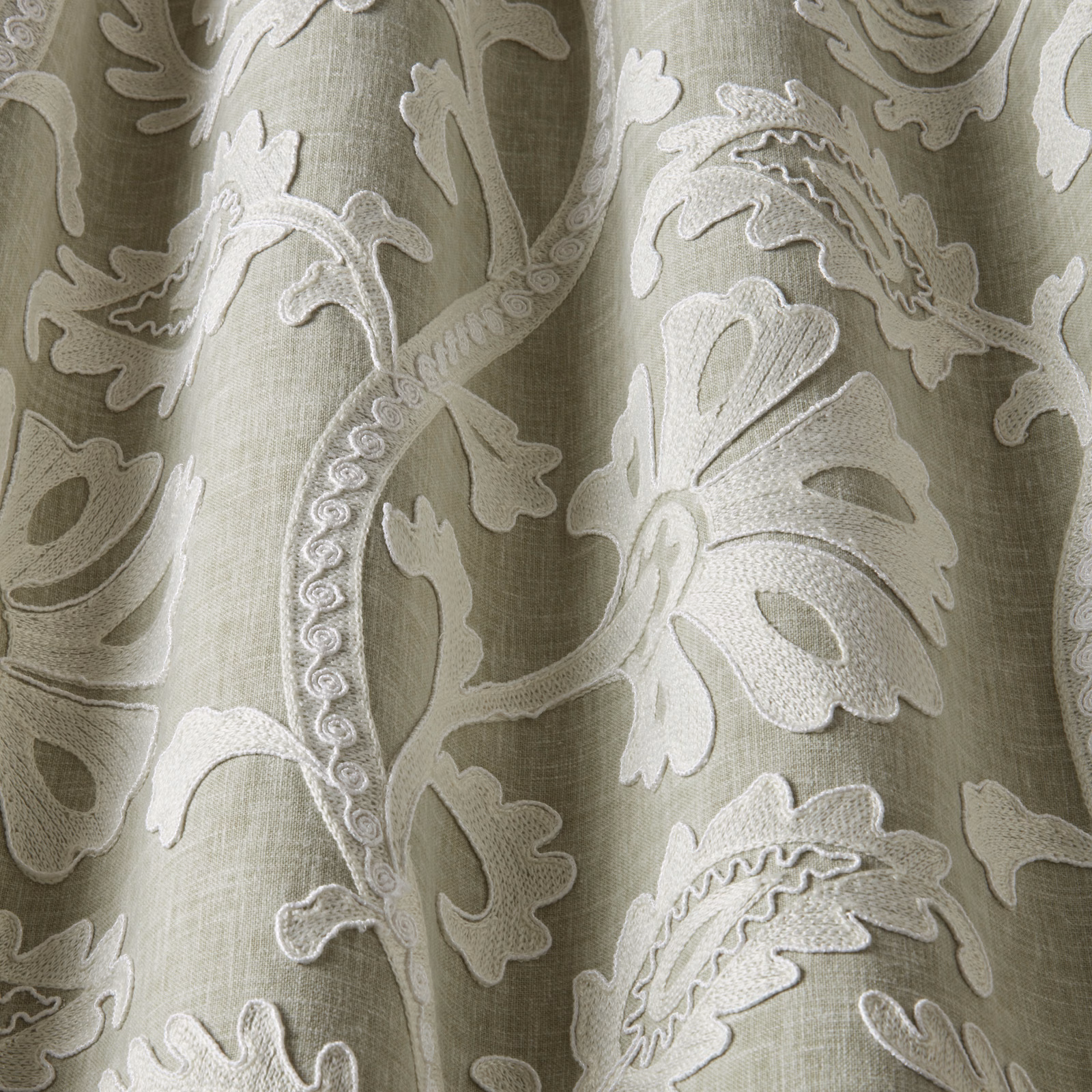 Soft sage green fabric with large ivory embroidered leaf and scrolling botanical motif