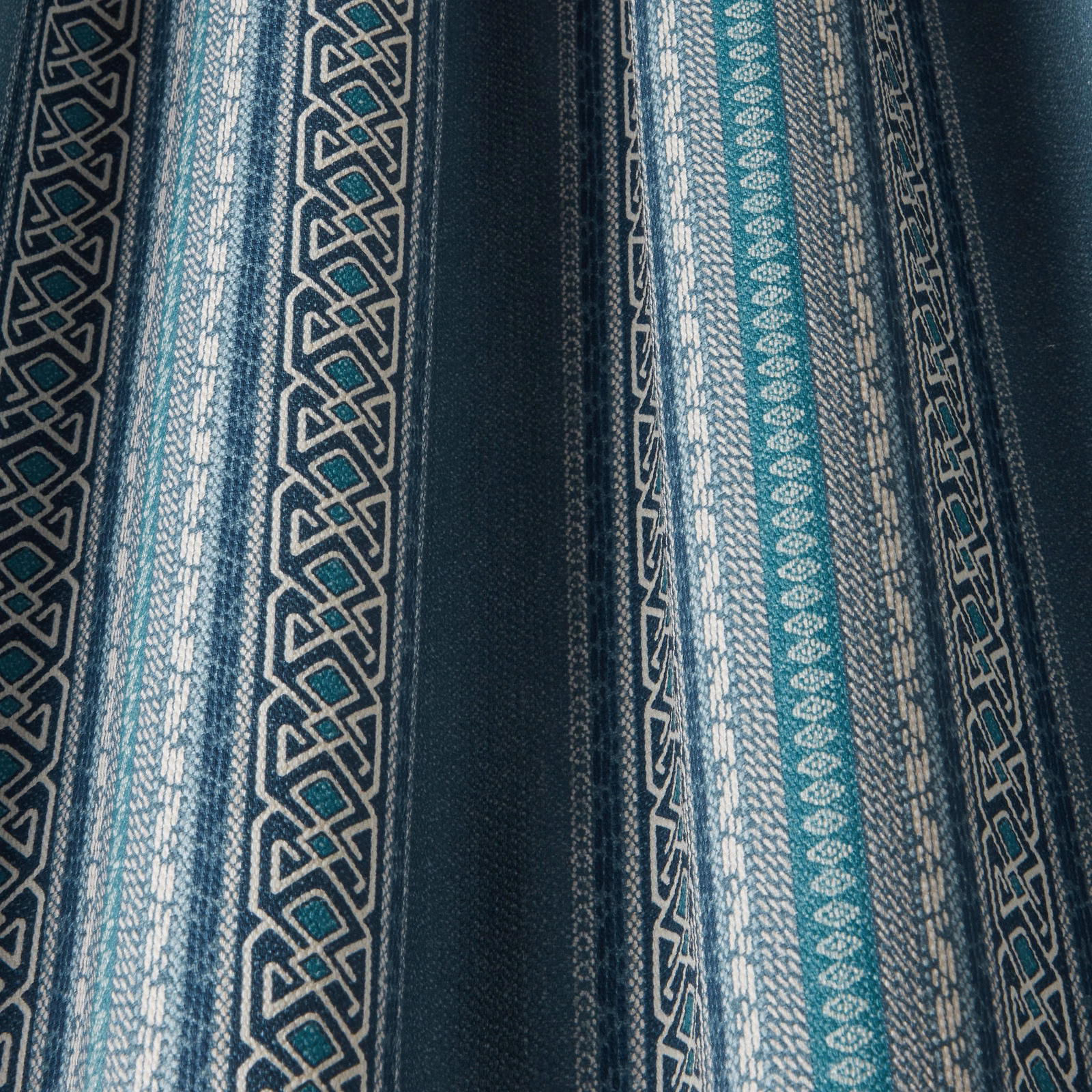 Vertical denim-blue and teal striped fabric with ivory geometric pattern bands