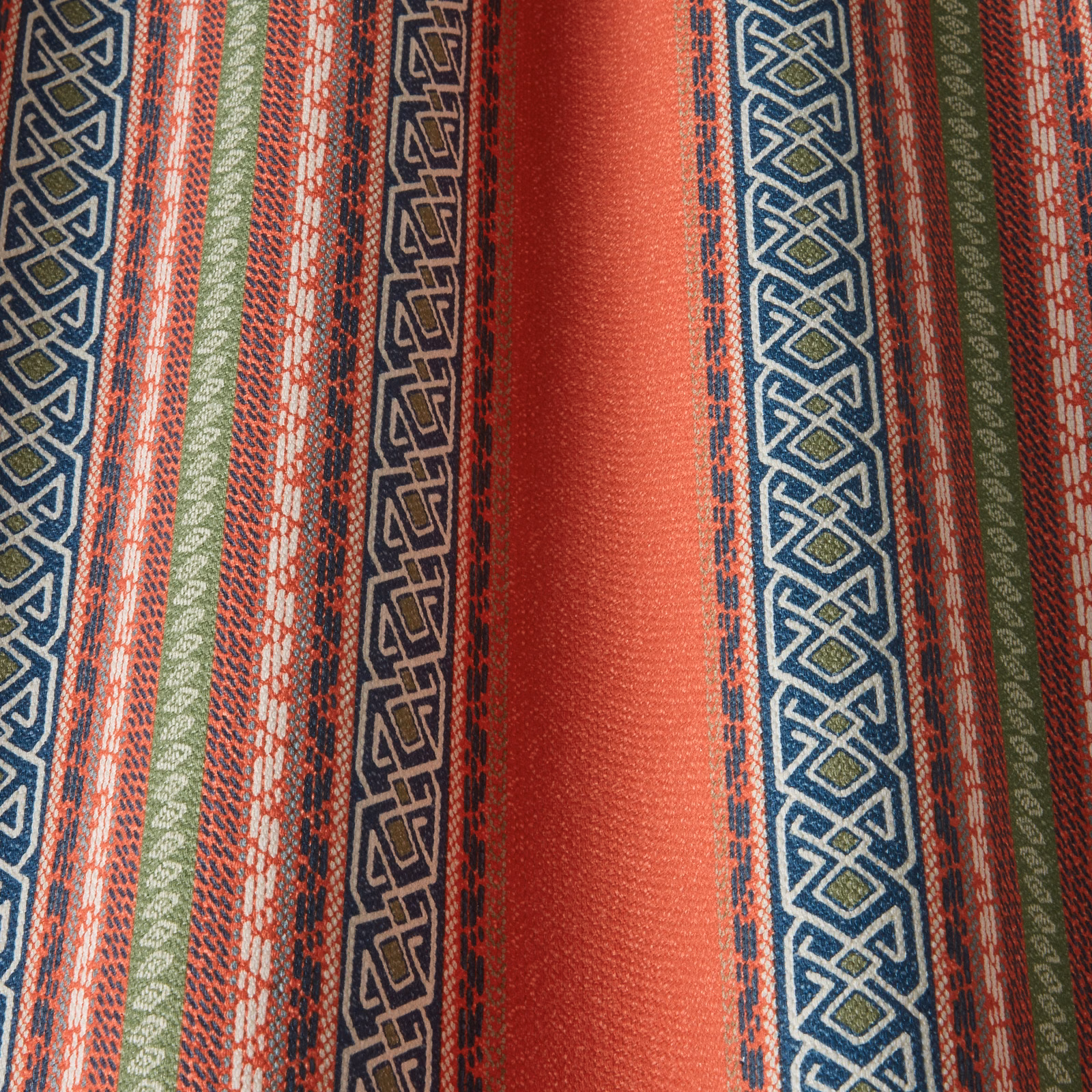 Close-up of striped lava red fabric with teal, olive and cream geometric bands