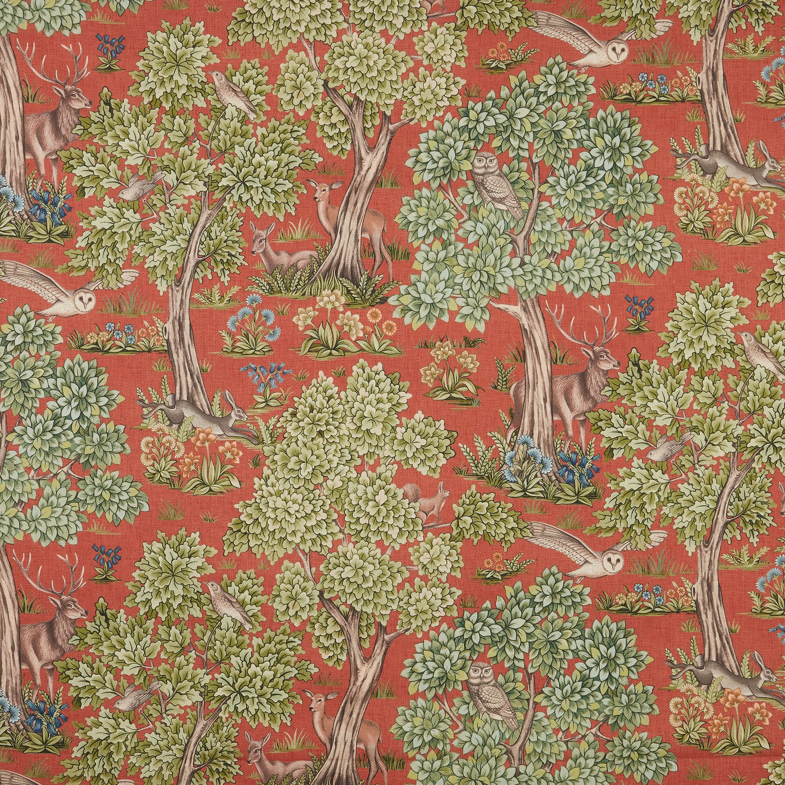 Woodland animal print fabric on a burnt terracotta red ground with leafy green trees