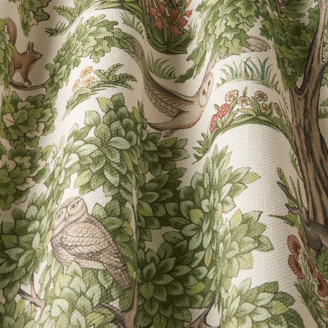 Sage green woodland bird and leaf print on a pale woven ground