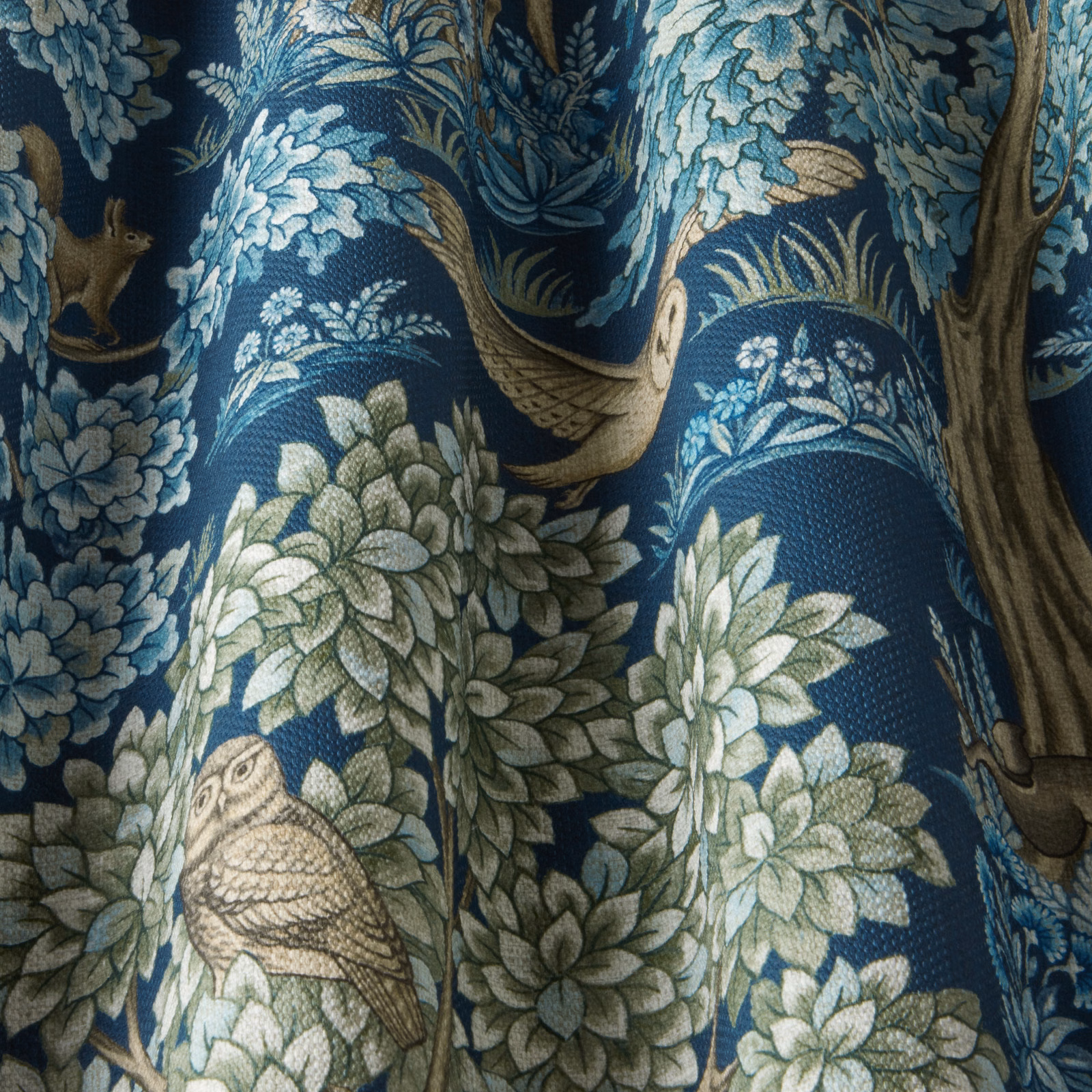 Sapphire blue woodland fabric with birds, leaves and tree motif