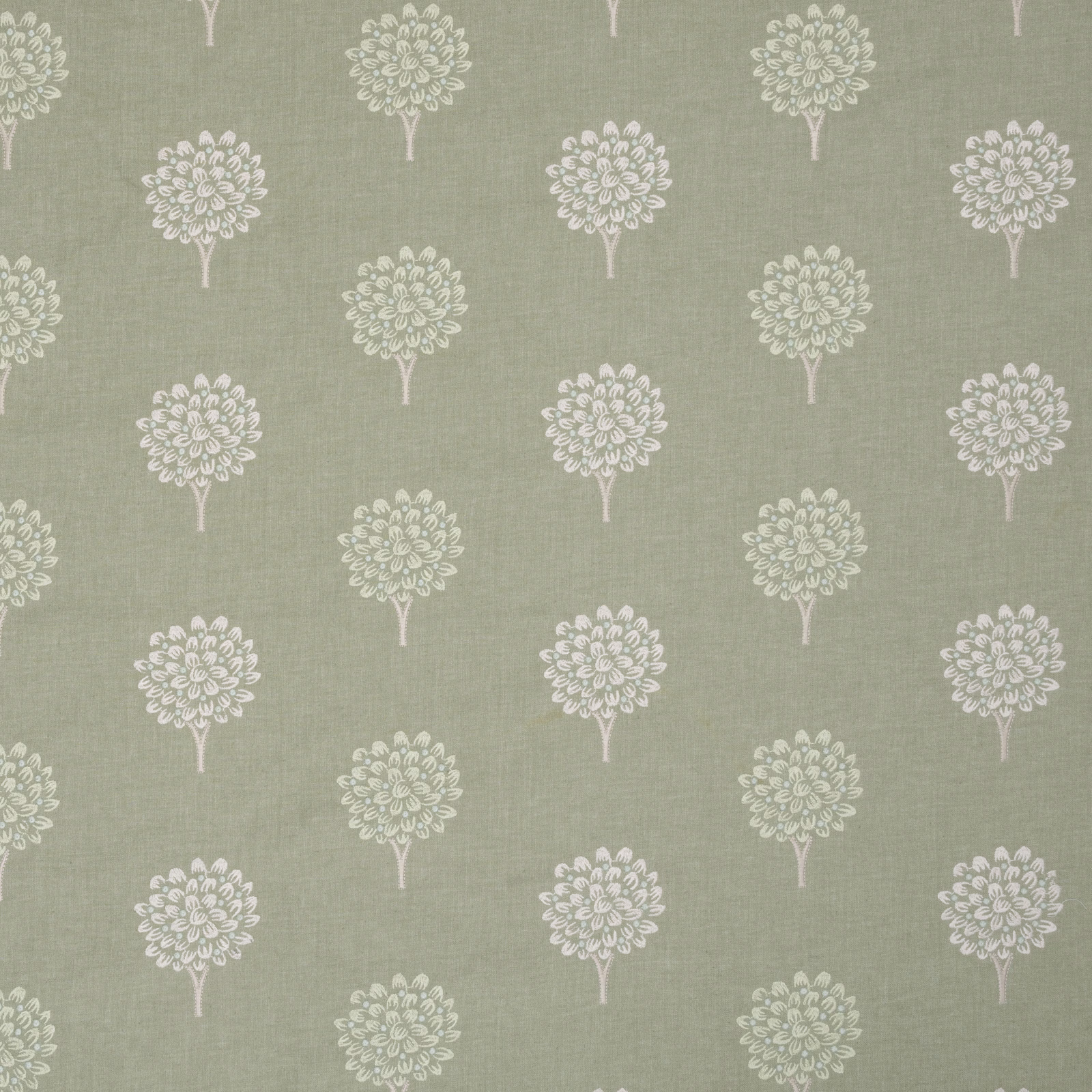 Embroidery of small ivory tree motifs on a soft sage-mint fabric ground