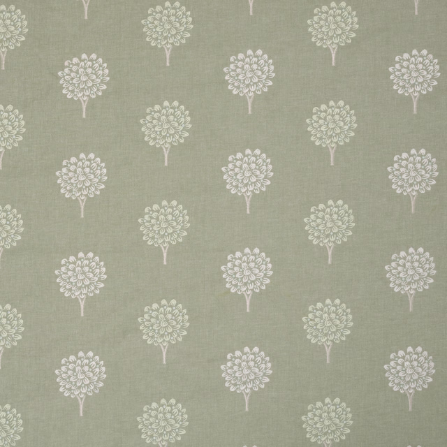 Embroidery of small ivory tree motifs on a soft sage-mint fabric ground