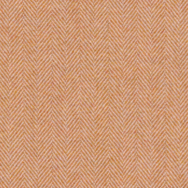 Warm gold herringbone weave with soft peach undertones in close-up