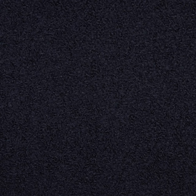 Near-black boiled wool bouclé with dense charcoal curls and low sheen