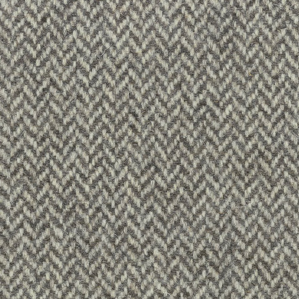 Muted grey-beige textile with small broken chevron weave and charcoal flecks