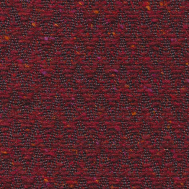 Deep garnet woven upholstery with broken charcoal chevrons and rust flecks