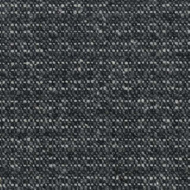 Close-up of charcoal-grey woven fabric with pale pebble flecks and irregular texture