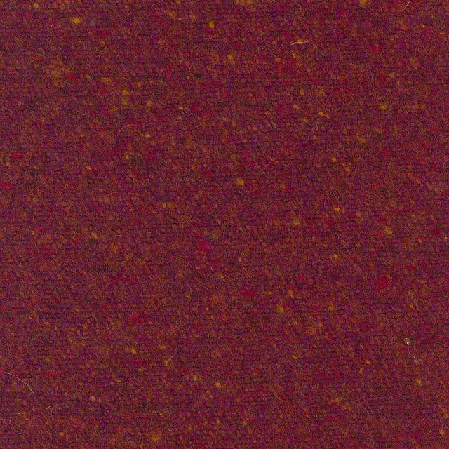 Close-up of burgundy-red woven fabric with russet and ochre flecks