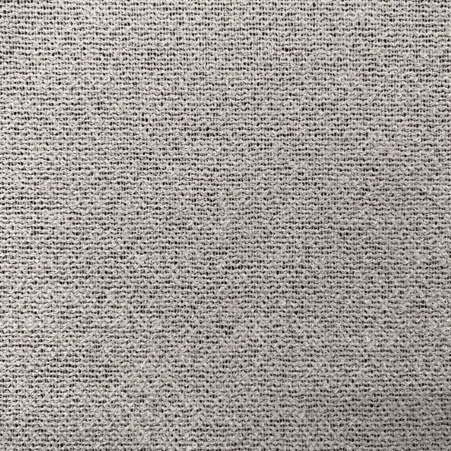 Close-up of soft white open weave with delicate grey flecks and textured threads