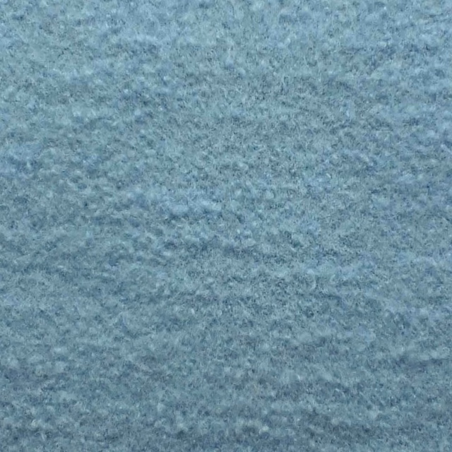 Close-up of pale Arctic blue-grey bouclé with a softly mottled, nubby texture