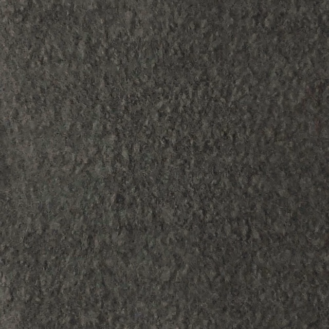 Close-up of dark charcoal-grey boucle with irregular fleecy loops and tonal mottling