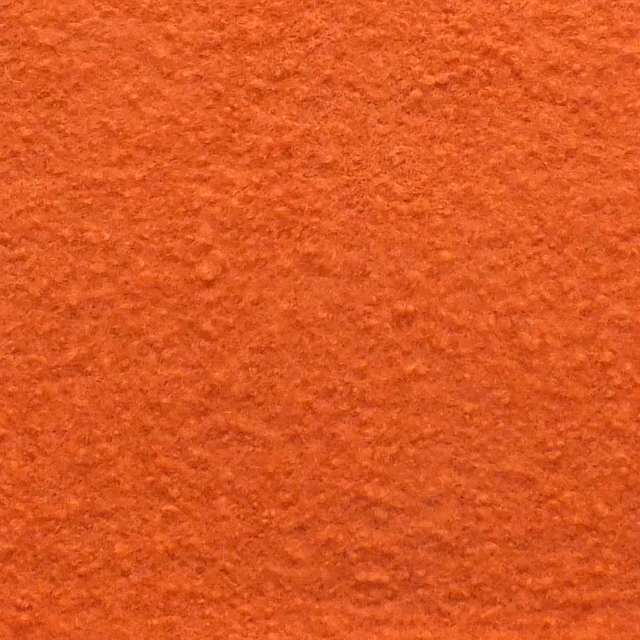 Warm peach-teracotta boucle with dense nubby texture and subtle rust variation