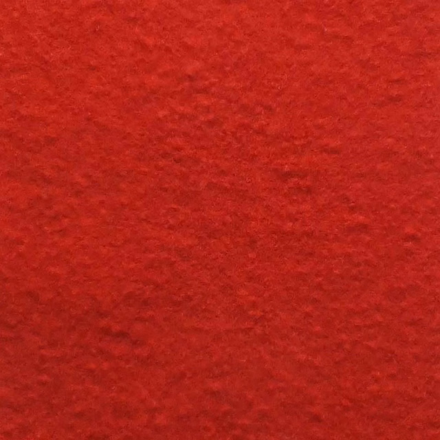 Close-up of deep scarlet red bouclé with dense, softly rippled pile texture