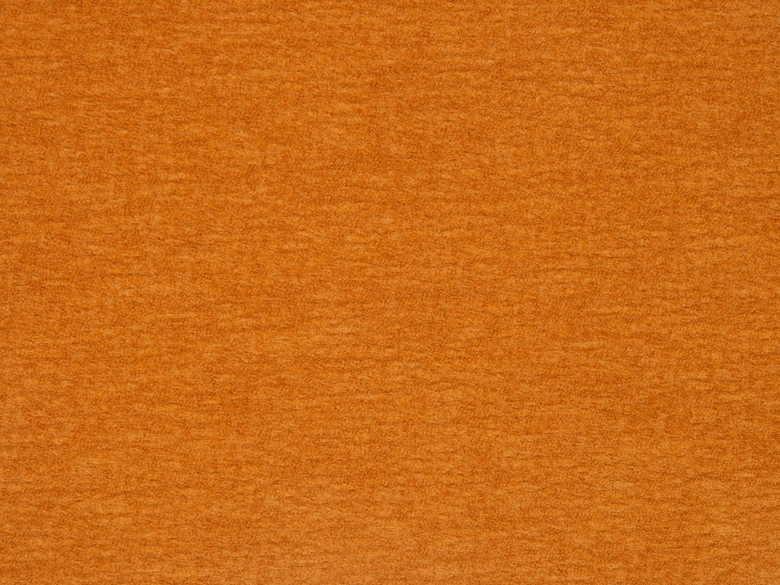 Close-up of plain pumpkin-orange fabric with a softly mottled woven texture