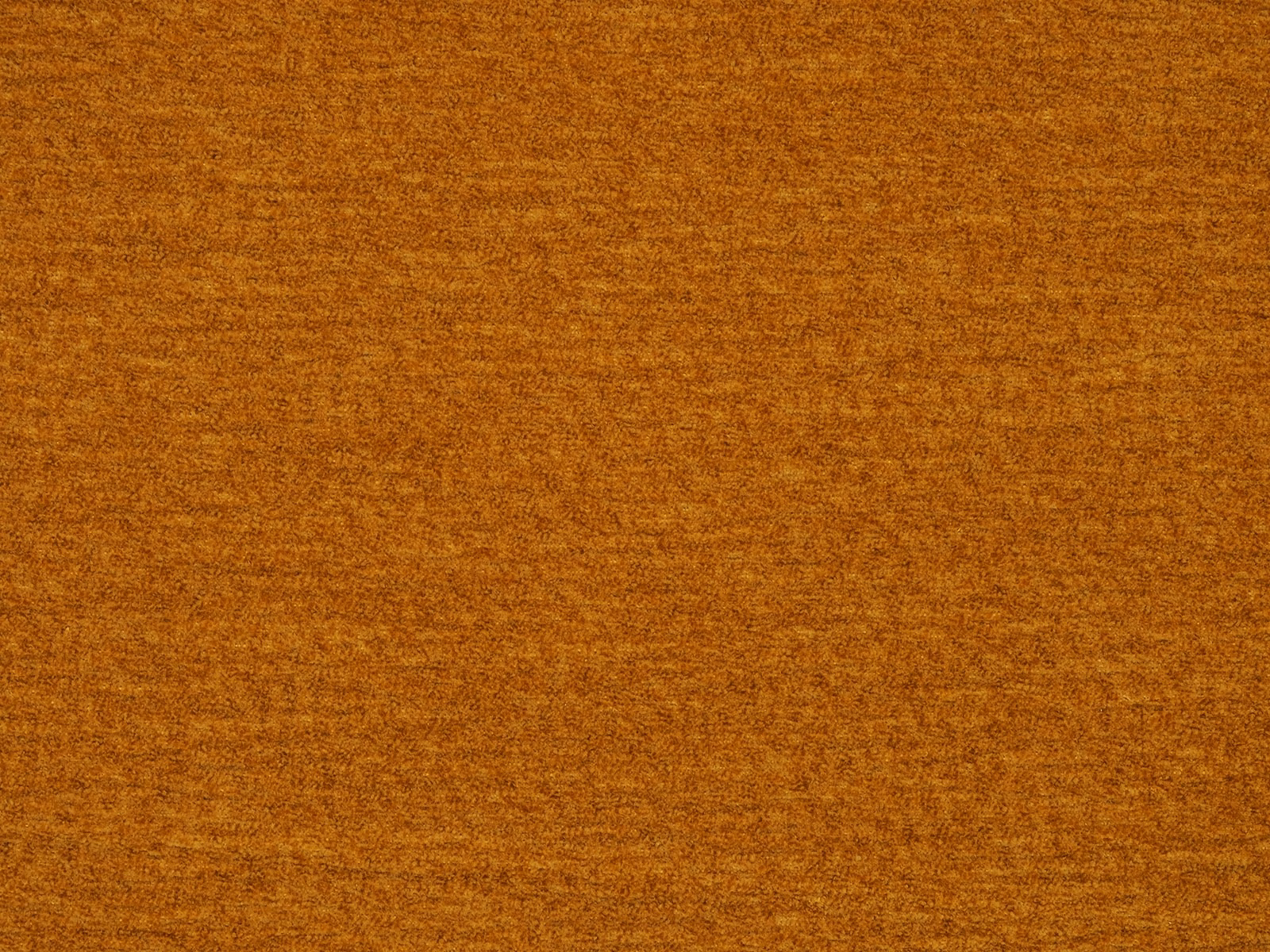 Close-up of a rich turmeric-gold plain fabric with a softly mottled, brushed texture