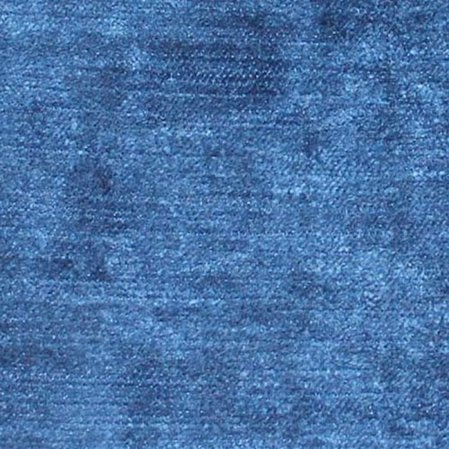 Close-up of a textured deep Prussian blue plain fabric with mottled light highlights