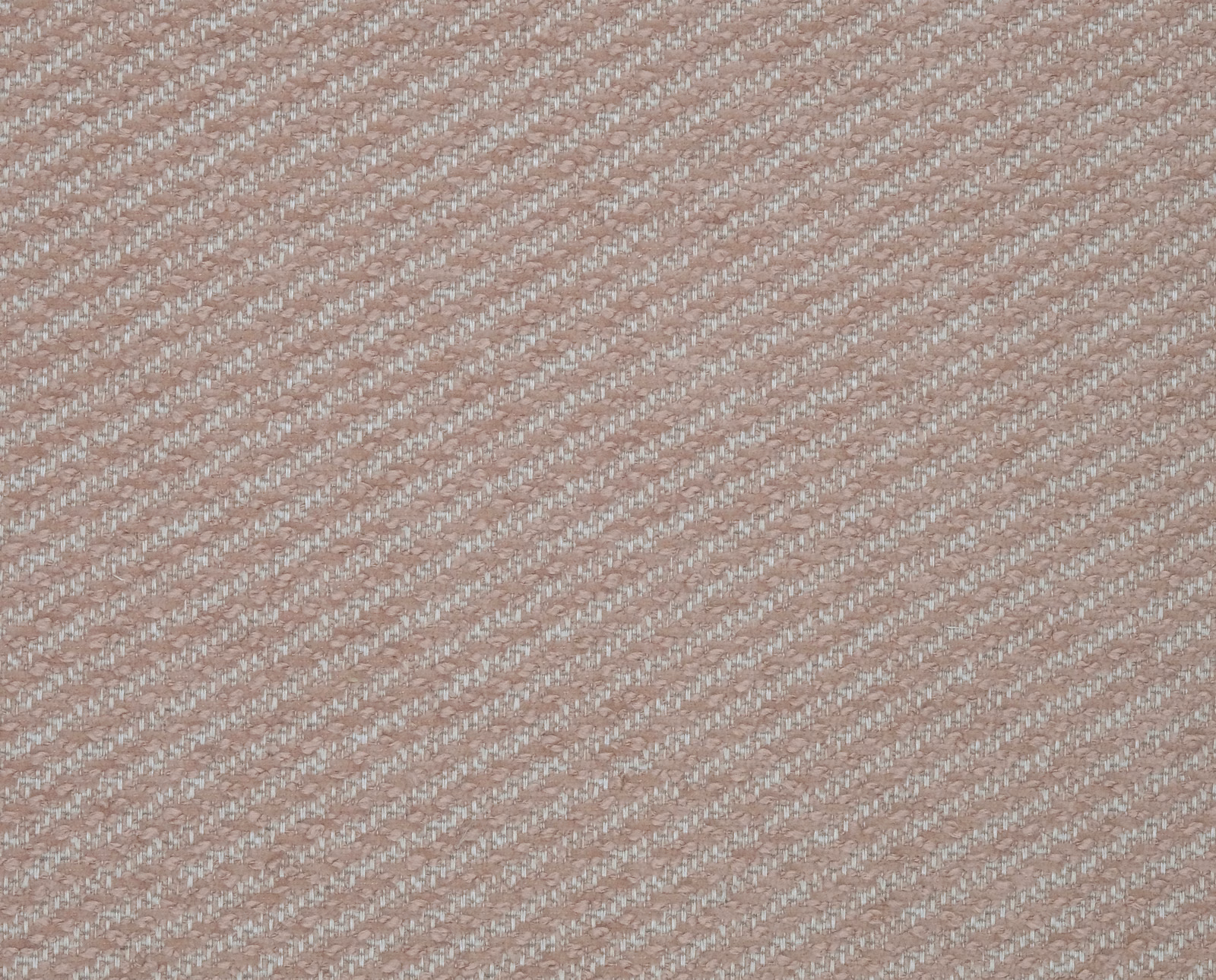 Close-up of soft blush pink diagonal woven fabric with subtle flecked texture