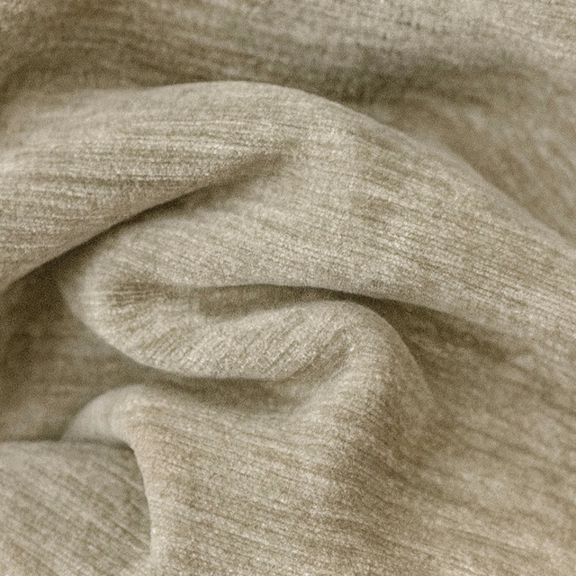 Warm beige slubbed plain fabric with soft folded texture