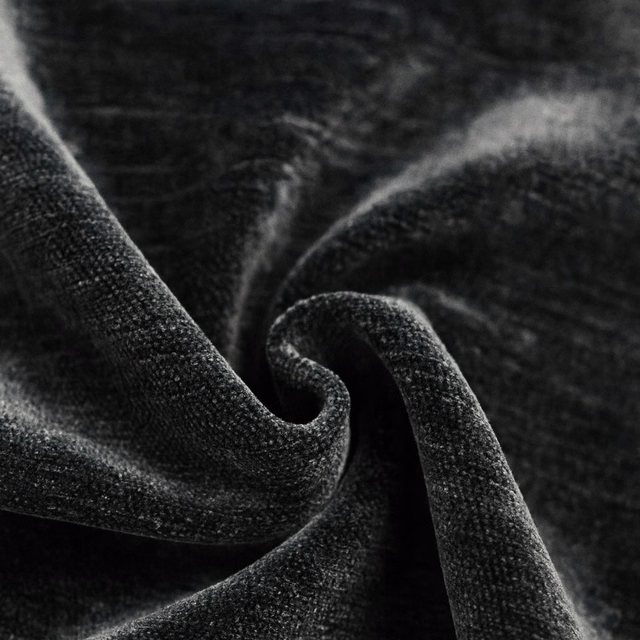 Close-up of a charcoal-black plain woven fabric with soft folded texture