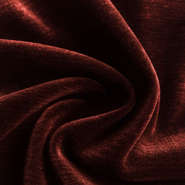 Close-up of deep oxblood red plain fabric with a soft sheen and folded drape