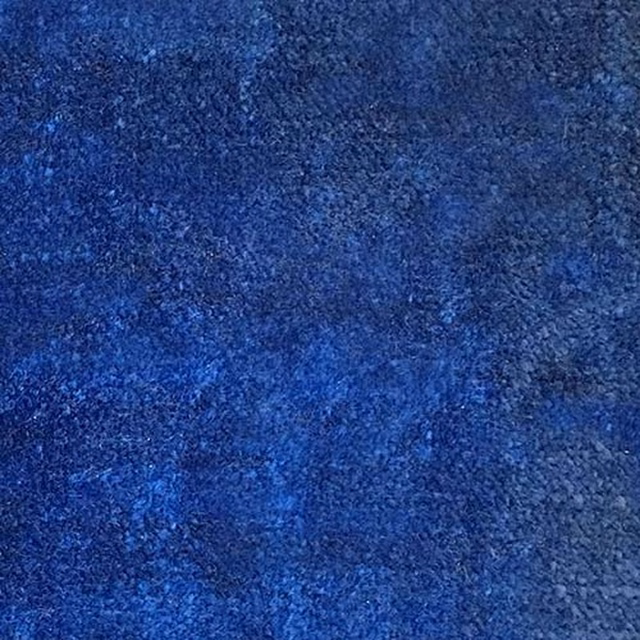 Close-up of deep blueberry blue plain fabric with a softly mottled texture