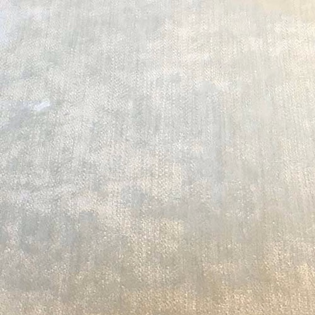 Pale ivory plain fabric swatch with a softly mottled, lightly lustrous texture