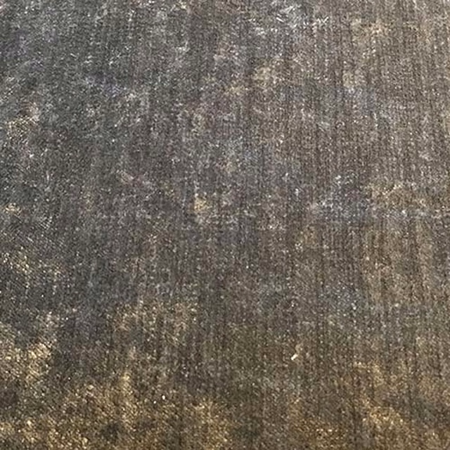 Close-up of a warm pewter-grey plain weave fabric with mottled olive-brown highlights