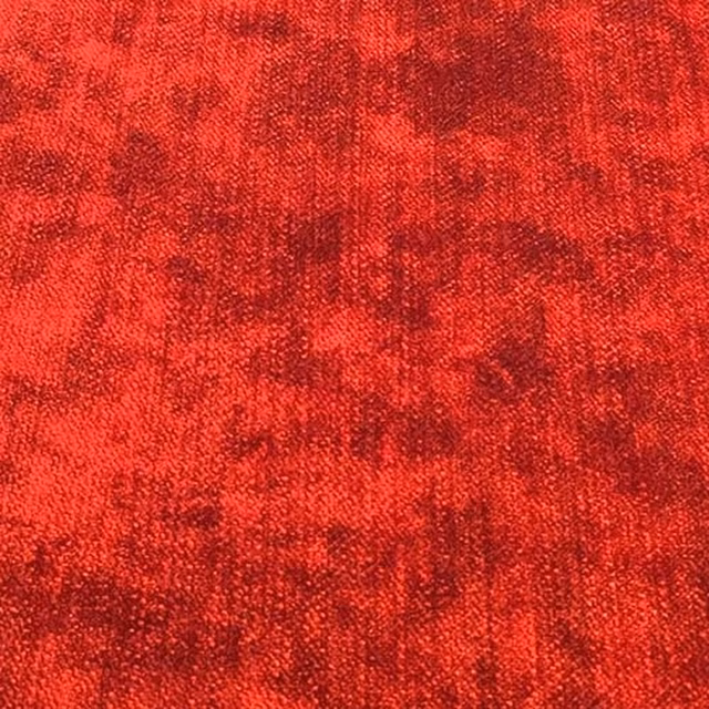 Close-up of vivid pillarbox red plain woven fabric with mottled texture