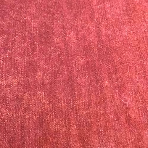 Close-up of a textured rose-pink plain fabric with a softly brushed sheen