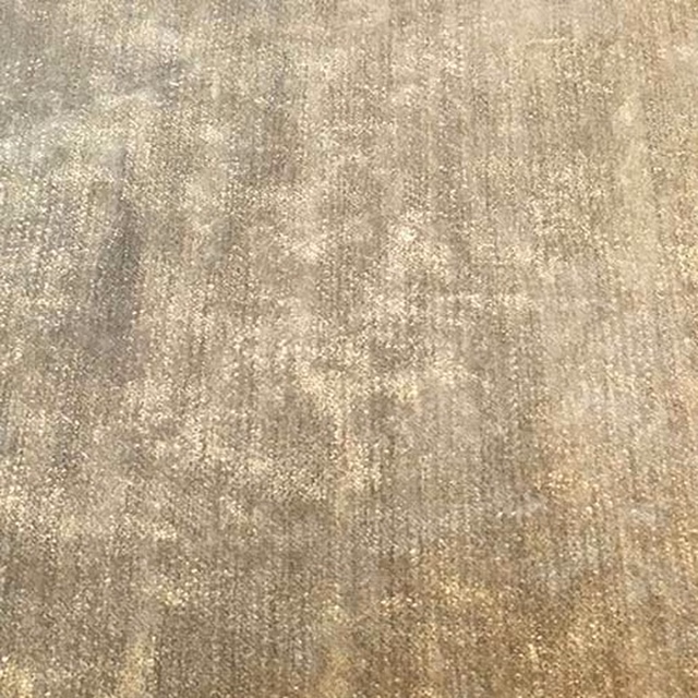 Close-up of warm sandy beige plain fabric with subtle mottled texture