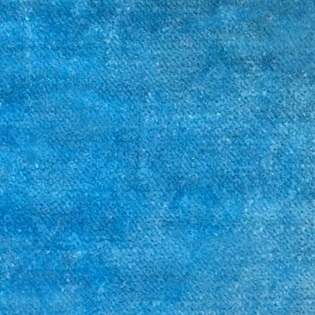 Close-up of bright turquoise blue plain upholstery fabric with a softly mottled texture