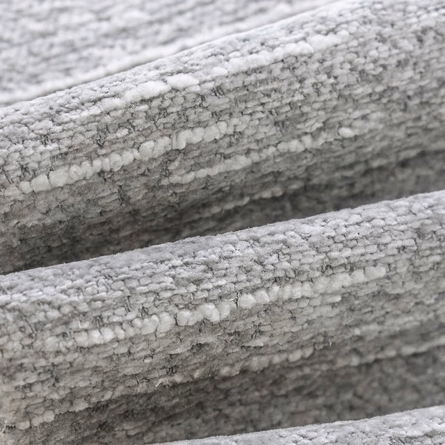 Close-up of pale dove grey bouclé fabric with ivory flecks and nubby texture