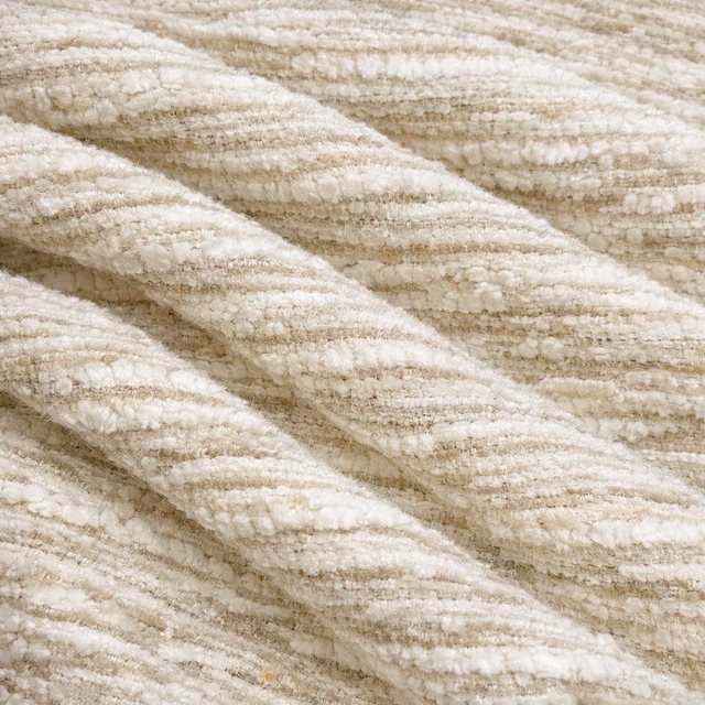 Close-up of soft oatmeal cream bouclé-textured upholstery fabric with subtle ribbed stripes