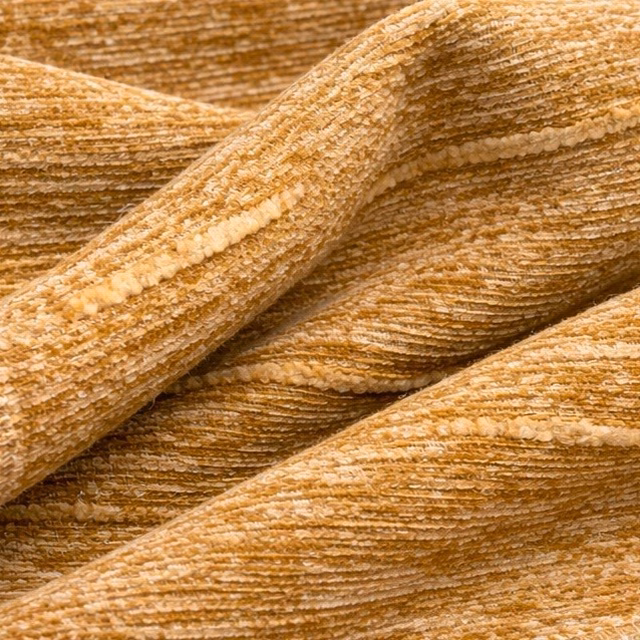 Close-up of marmalade-gold ribbed fabric with slubbed texture and soft sheen