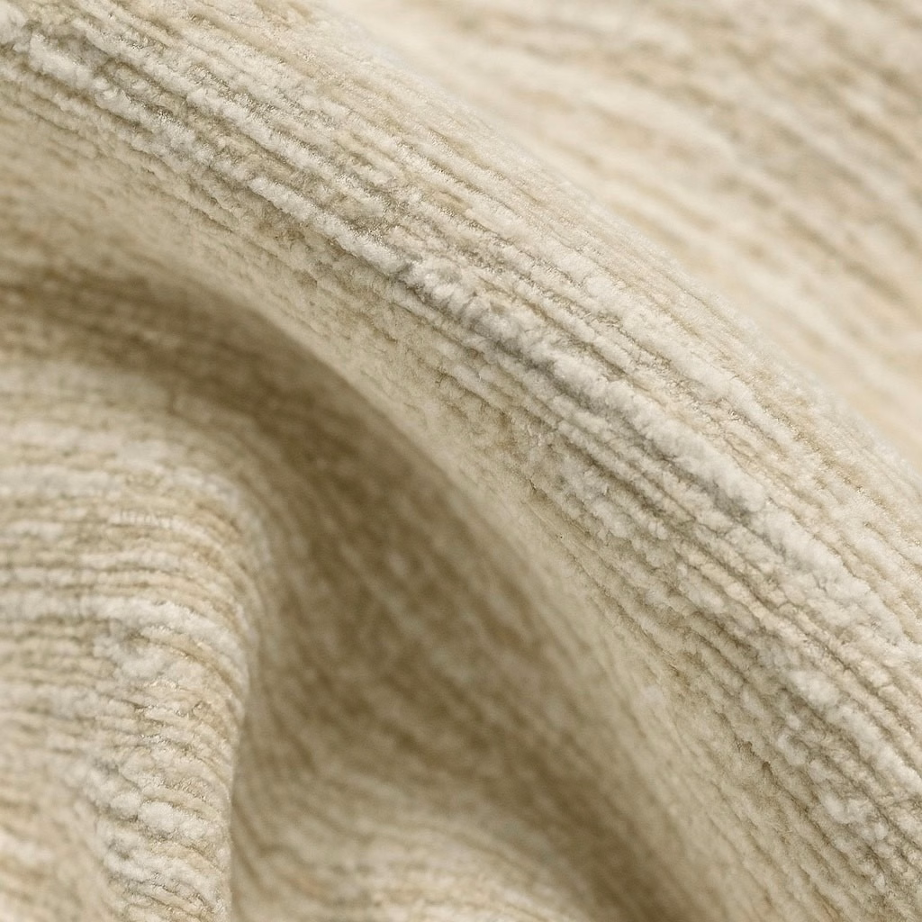 Close-up of soft sandstone beige ribbed plain fabric with gently folded texture