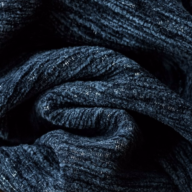 Close-up of deep sapphire blue textured plain fabric with subtle flecked yarn